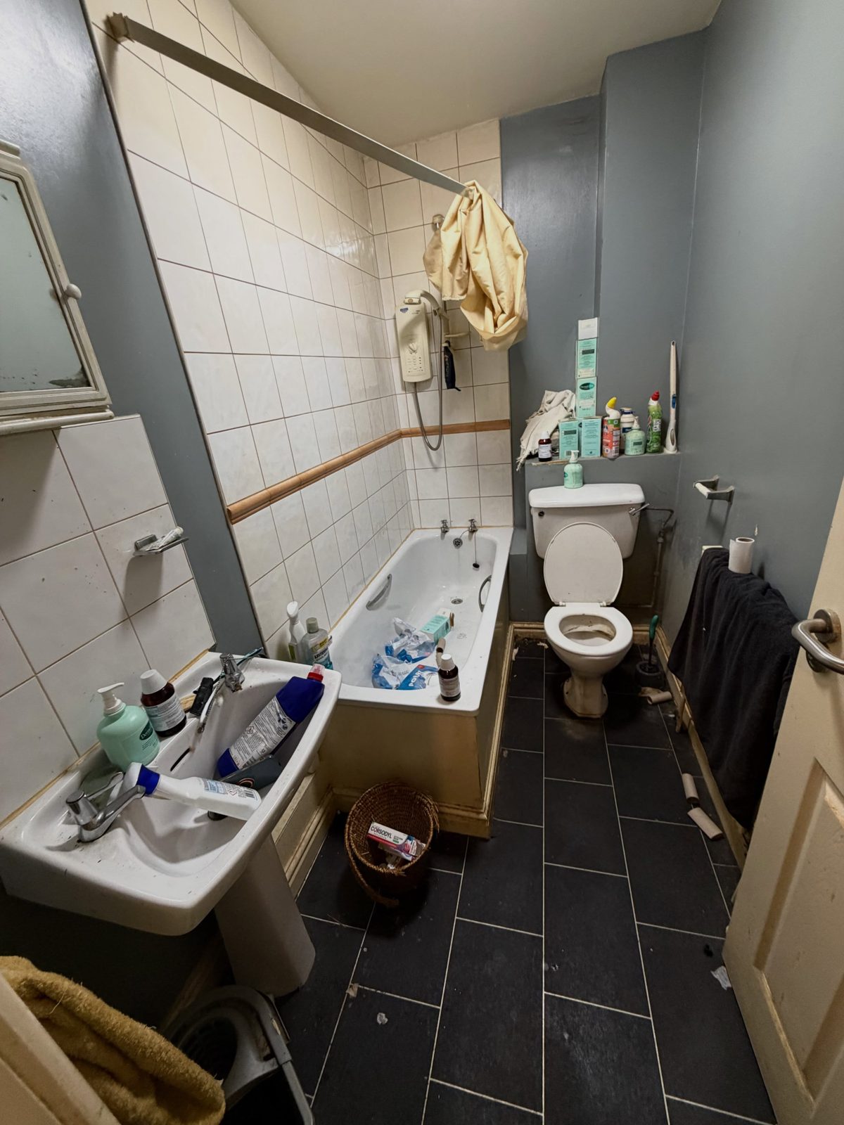 Vinny’s bathroom before the clean, cluttered with bottles and rubbish