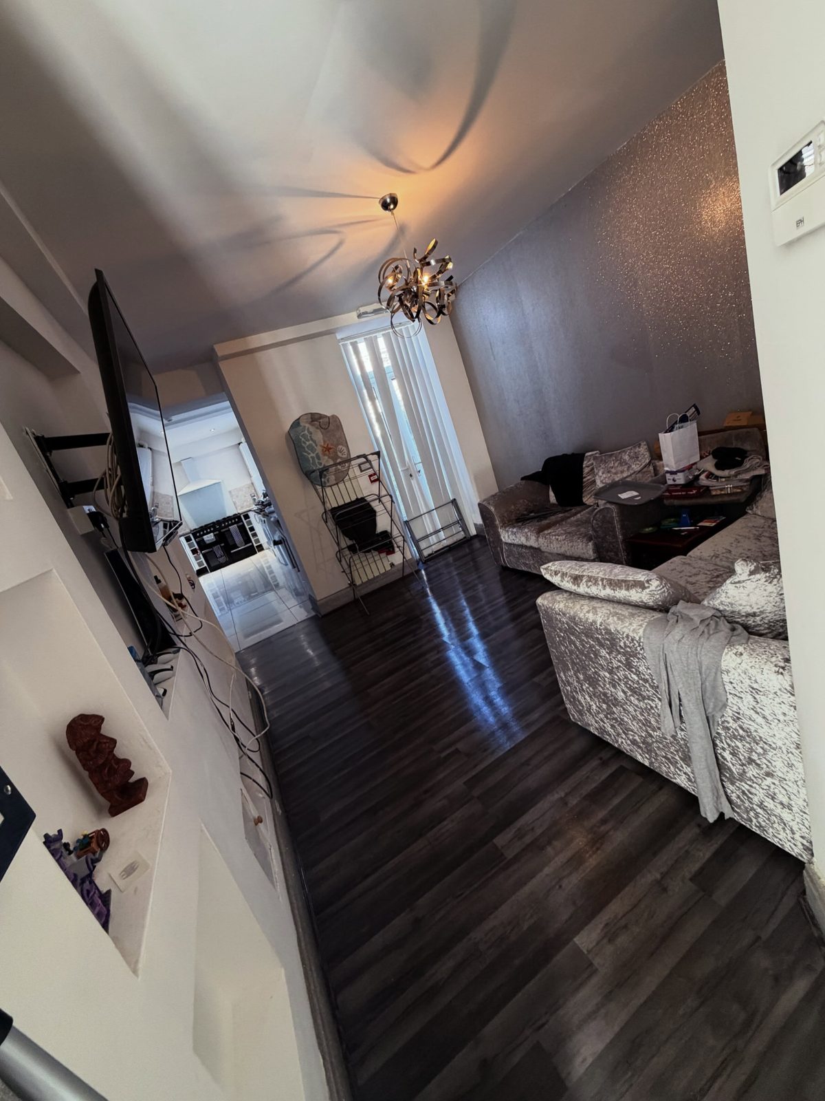 A clean, bright communal lounge and hallway with dark wood floors
